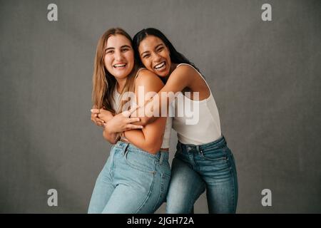 Two female friends hugging and laughing and just having fun Stock Photo