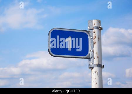 Road sign 1 km against the blue sky with white clouds Stock Photo