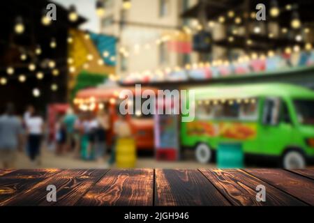 Wooden table on blurred hipster street food urban market background. Empty placement desk for product or food and drink. Lifestyle concept. Selected focus . High quality photo Stock Photo