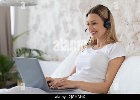 Happy blonde woman freelancer working from home Stock Photo