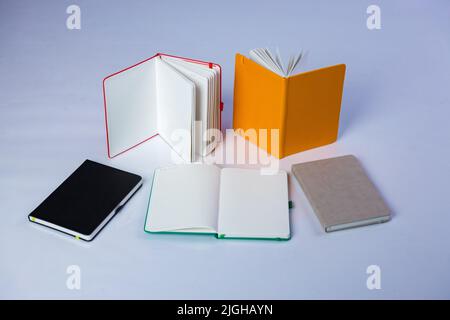 Colourful journals placed open and closed. Beautiful studio photo of notebooks pens on white background. . High quality photo Stock Photo