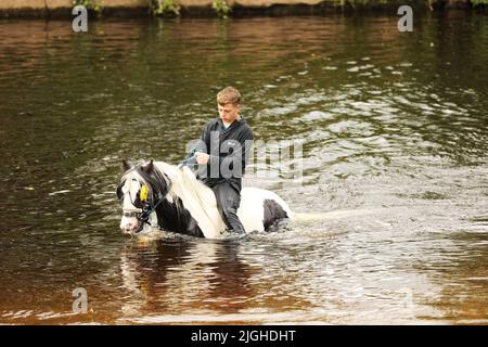 A teenage boy and his horse in the River Eden, Appleby Horse Fair, Appleby in Westmorland, Cumbria Stock Photo