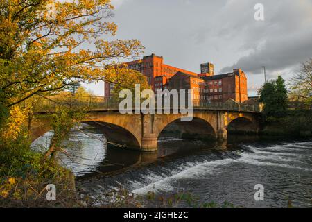 Belper Bridge over the River Derwent with North Mill and the larger East Mill behind.  Belper, Derbyshire, UK Stock Photo