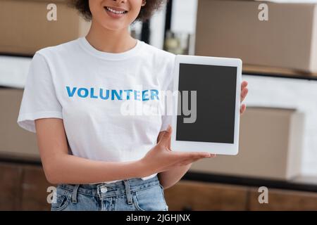 Premium Photo  Side view portrait of female volunteer holding tablet organizing  boxes at help and donations event