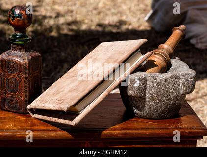 stone mortar and pestle on a wooden table with a book Stock Photo