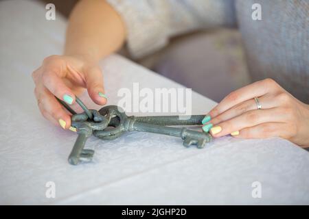 Woman's hands hold vintage keys. Pick up the key to the heart. Stock Photo