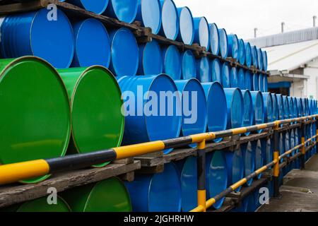 Oil barrels blue and green or chemical drums horizontal stacked up Stock Photo