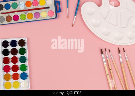 Back to school. Brushes, paints and palette on the table. A set of brushes of different sizes, bright multi-colored paints for drawing on a beautiful Stock Photo
