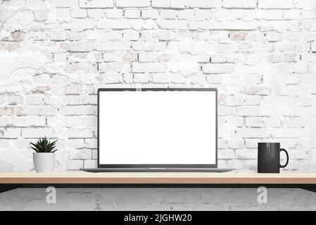 Laptop mockup on desk with brick wall in background. Isolated displaz in white for mockup, app or web page promotion. Plant and coffee mug beside. Fro Stock Photo