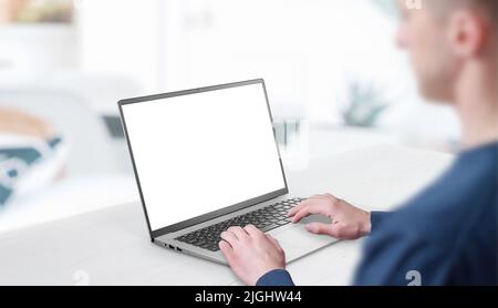 Mockup image of a man working at the laptop. Clean desk with office interior in background. Isolated screen in white for web page promotion Stock Photo