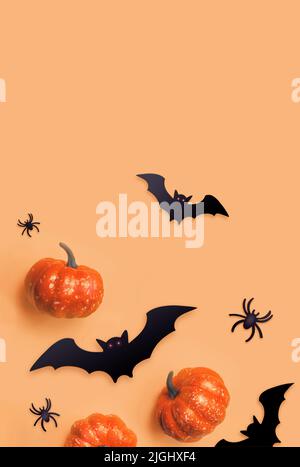 Orange Halloween background. Black bats and orange pumpkins. Autumn decoration. Halloween concept. Top view. Stock Photo