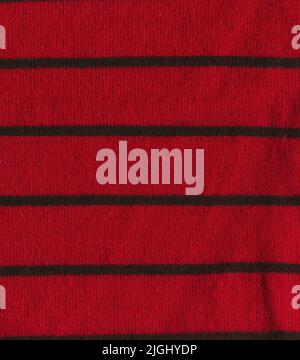 Magneta knitted background with copy space. Fabric poppy red colored colored texture with black stripes. Stock Photo