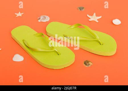 Beach accessories. Flip flops and starfish on colored background. Top view Mock up with copy space. Stock Photo
