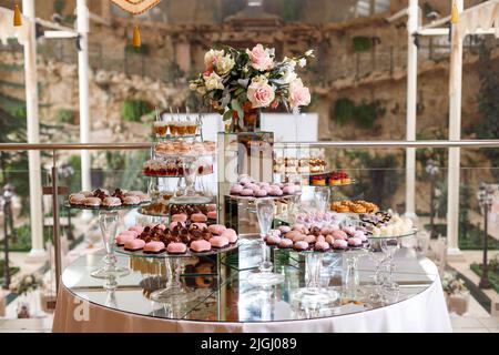 Served festive candy bar table with cupcakes, macaroons, sweets and other desserts. Celebrating a wedding, birthday, friends party, prom or other holi Stock Photo