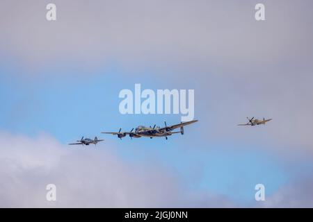 An RAF Hurricane and Spitfire flank a Lancaster bomber forming the Battle of Britain Memorial Flight displaying at Southport Air Show, Merseyside, UK Stock Photo