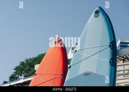 Close up of a stand up paddle board SUP and paddle on a dock. Outdoor water sports. Surfing lifestyle. Stock Photo