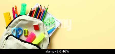 Backpack with school stationery on yellow background. School supplies sale banner. Back to school concept. Stock Photo