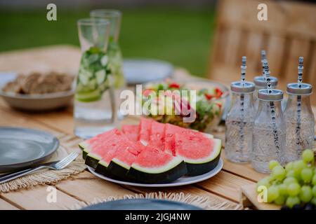 Dining table set for dinner on the terrace in summer, garden party concept. Stock Photo