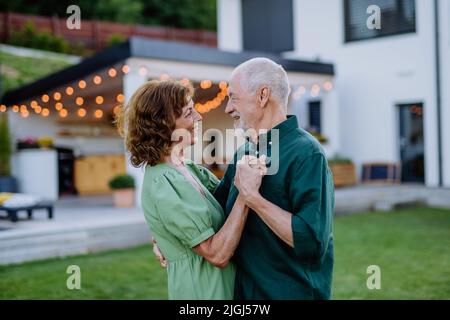 Senior woman nad man dancing together in a garden in summer Stock Photo