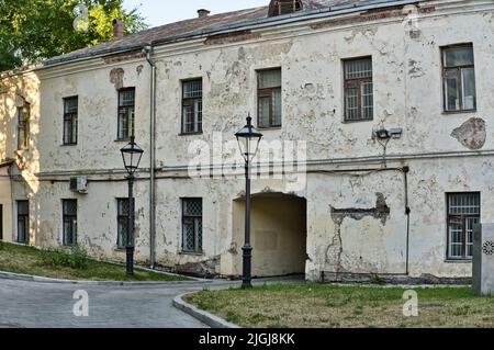 The fragment of the old building facade. Cracks on the plaster and broken windows. Emergency residential building. Stock Photo