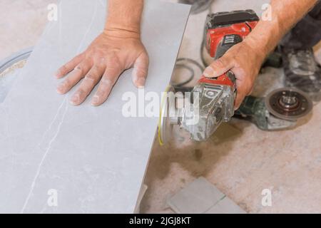 Worker polishing corner tiles on angle grinder using diamond grinding disc for angle grinder polishing Stock Photo
