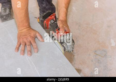 The worker uses the diamond polishing disk from an angle grinder in order to polish the cut corners Stock Photo