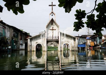 An abandoned church is seen submerged inside the Artex Compound in Malabon, Metro Manila. The village has been flooded by stagnant waters for several years. The inhabitants, who are mostly poor, have to use boats for their daily mode of transportation, and even visiting their neighbors has become a tedious effort. In order to get access to basic necessities like groceries, residents need transport to other parts of the city that are not flooded. One of the biggest problems for the residents living in the area is getting clean water for day-to-day life. Philippines. Stock Photo