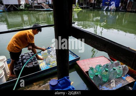 A man collects water using plastic containers at a small dock inside the Artex Compound in Malabon, Metro Manila. The village has been flooded by stagnant waters for several years. The inhabitants, who are mostly poor, have to use boats for their daily mode of transportation, and even visiting their neighbors has become a tedious effort. In order to get access to basic necessities like groceries, residents need transport to other parts of the city that are not flooded. One of the biggest problems for the residents living in the area is getting clean water for day-to-day life. Philippines. Stock Photo