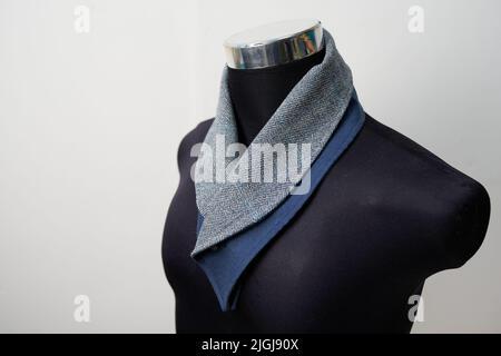 Black mannequin with gray and blue scarf for formal wear, turtleneck style. Stock Photo