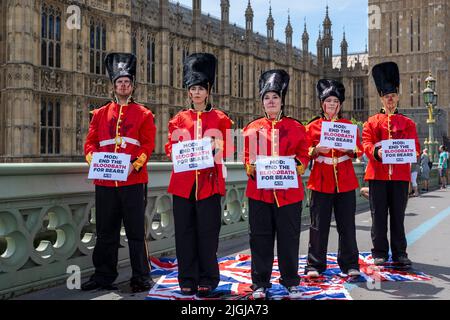 London, UK.  11 July 2022.  Members of PETA (People for the Ethical Treatment of Animals) stage a stunt on Westminster Bridge dressed as Queen’s Guards covering themselves in fake blood.  The stunt is ahead of a debate in Parliament in which MPs will discuss replacing the bearskins used for the Queen’s Guard’s caps with faux fur.  Credit: Stephen Chung / Alamy Live News Stock Photo