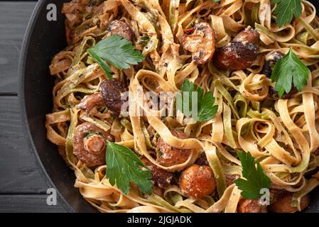 Homemade Italian fettuccini or alfredo pasta, also called Funghi Porcini cooked in a cast iron skillet with mushrooms and cream sauce Stock Photo