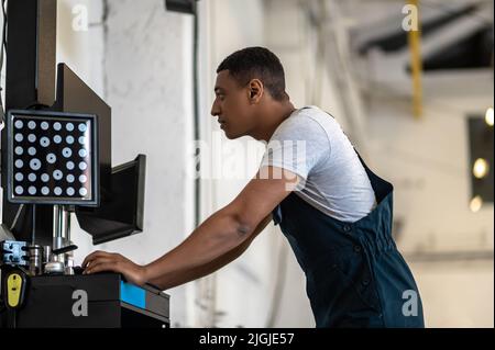 Mechanic working on the computer in the auto repair shop Stock Photo