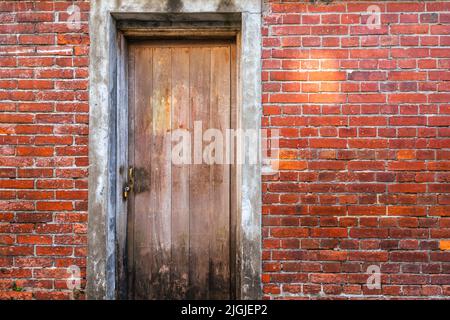 A old locking wooden door with the red brick wall.(Bopiliao history block in Wanhua district, Taipei, Taiwan) Stock Photo