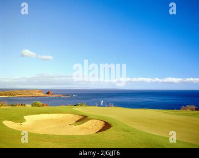 The 17th hole green of the Manele Golf Courses which overlooks the Pacific Ocean at the Four Seasons Resort Lana'i at Manele Bay. Lana'i, Hawaii, USA. Stock Photo