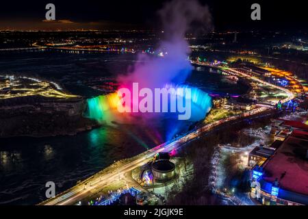 Aerial view of Horseshoe Falls winter illumination in twilight time. Niagara Falls City downtown horizon. Stunning landscape dusk to night. Stock Photo