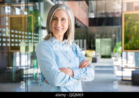 Portrait of smiling confident 60-s gray-haired mature woman. Stock Photo