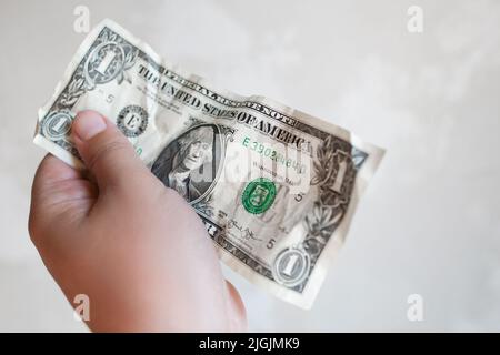 Male hand hold one dollar bill in giving gesture Stock Photo