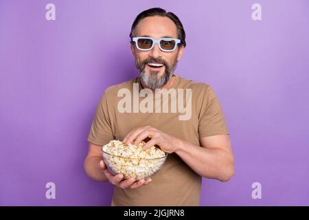 Photo of positive male spend free weekend time watching movies in 3d cinema isolated on violet color background Stock Photo