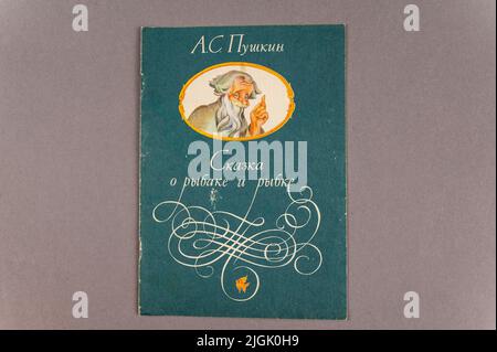 Russian folk tale About the Fisherman and the Fish. A fairy tale by the famous Russian writer and poet Alexander Pushkin. An old book against a gray b Stock Photo