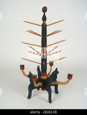 Julträd Christmas tree of wood. Made in birch, with egg oil temperature painting. Foot with four stylized horses painted in blue. Watched middle tribe painted in yellow, blue and red. On the trunk 'apple sticks' in yellow color. Four yellow -painted light arms with red/blue candle holders. On top bird. Disassembled construction. Making manufacturer, Herman Gustavsson has made Christmas trees and other traditional candlesticks for a long time. Herman took over the production after Johan Karlsson in Bettamåla, which began to manufacture Christmas trees for the Hemslöjden in the 1930s. Stock Photo