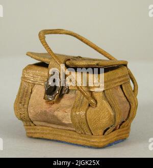 Korg Sewing basket, of leather, paper, fabric, metal. Cardboard frame covered with leather and fabric. Buckle in white metal, rusty. Small metal bud on the lid. Handle on the sides. One is missing. Contains two wooden wire rolls, H: 20, Diam: 13mm. Earlier acquisitions. Unmarked Stock Photo