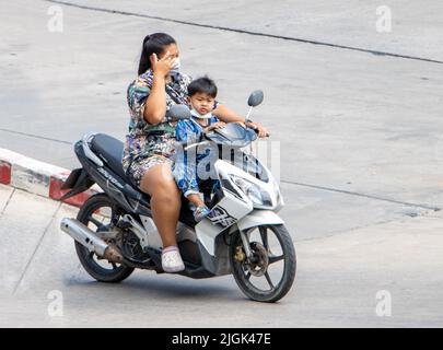 SAMUT PRAKAN, THAILAND, MAR 29 2022, A woman rides boy on a motorcycle. Stock Photo