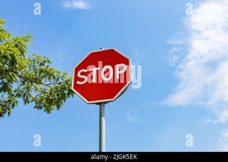 A traffic STOP sign on the blue sky background Stock Photo