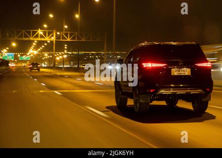 BANGKOK, THAILAND, APR 15 2022, A suv car is driving on the night highway Stock Photo