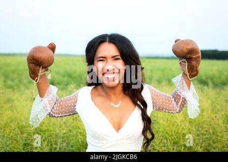 portrait of a beautiful african-american bride posing with boxing gloves Stock Photo