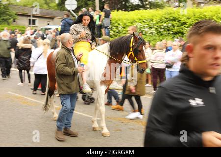 A young woman with long black hair riding a coloured horse on the road, Appleby Horse Fair, Appleby in Westmorland, Cumbria Stock Photo