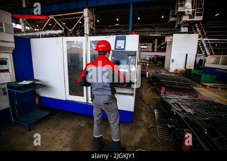 Operator works with CNC laser cutting machine Stock Photo
