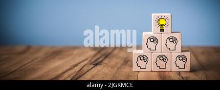 Wooden Blocks on Table With Team And Lightbulb Symbol - Success Through Teamwork Concept Stock Photo