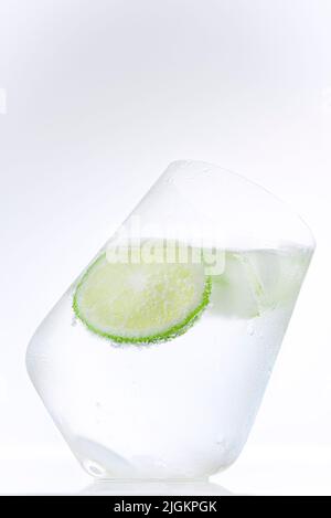 Cold mineral water with lime and cucumber slice on a white background, isolated Stock Photo