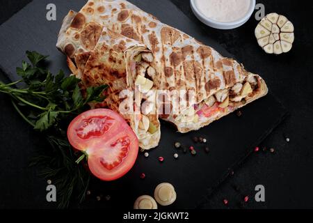 Shawarma with chicken meat and mushrooms, on a dark background Stock Photo